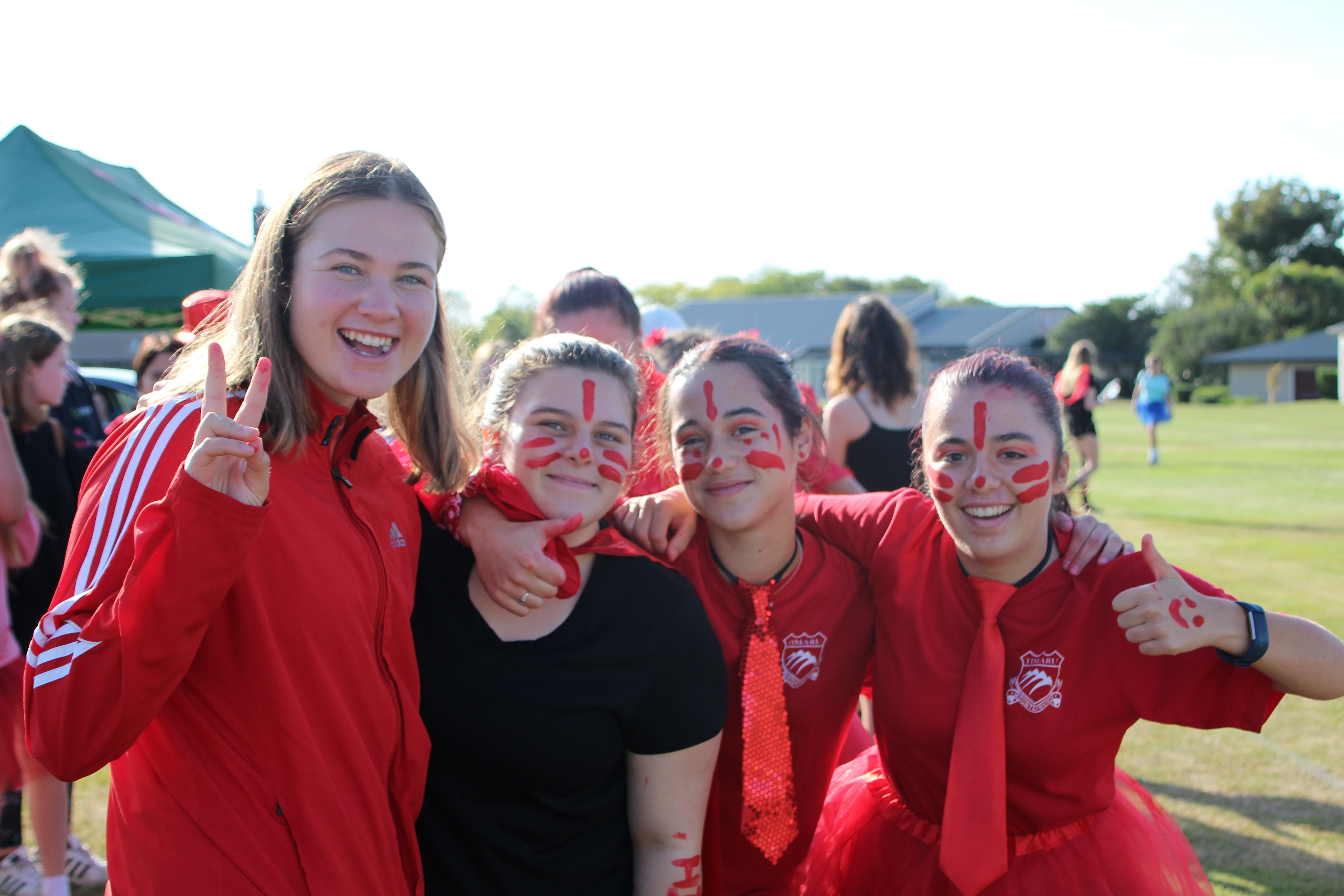 Four students smiling with their arms over each others shoulders.