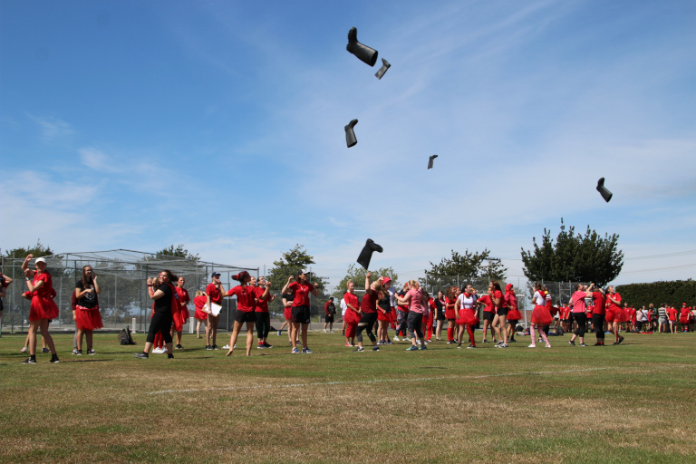 Students in line throwing gumboots